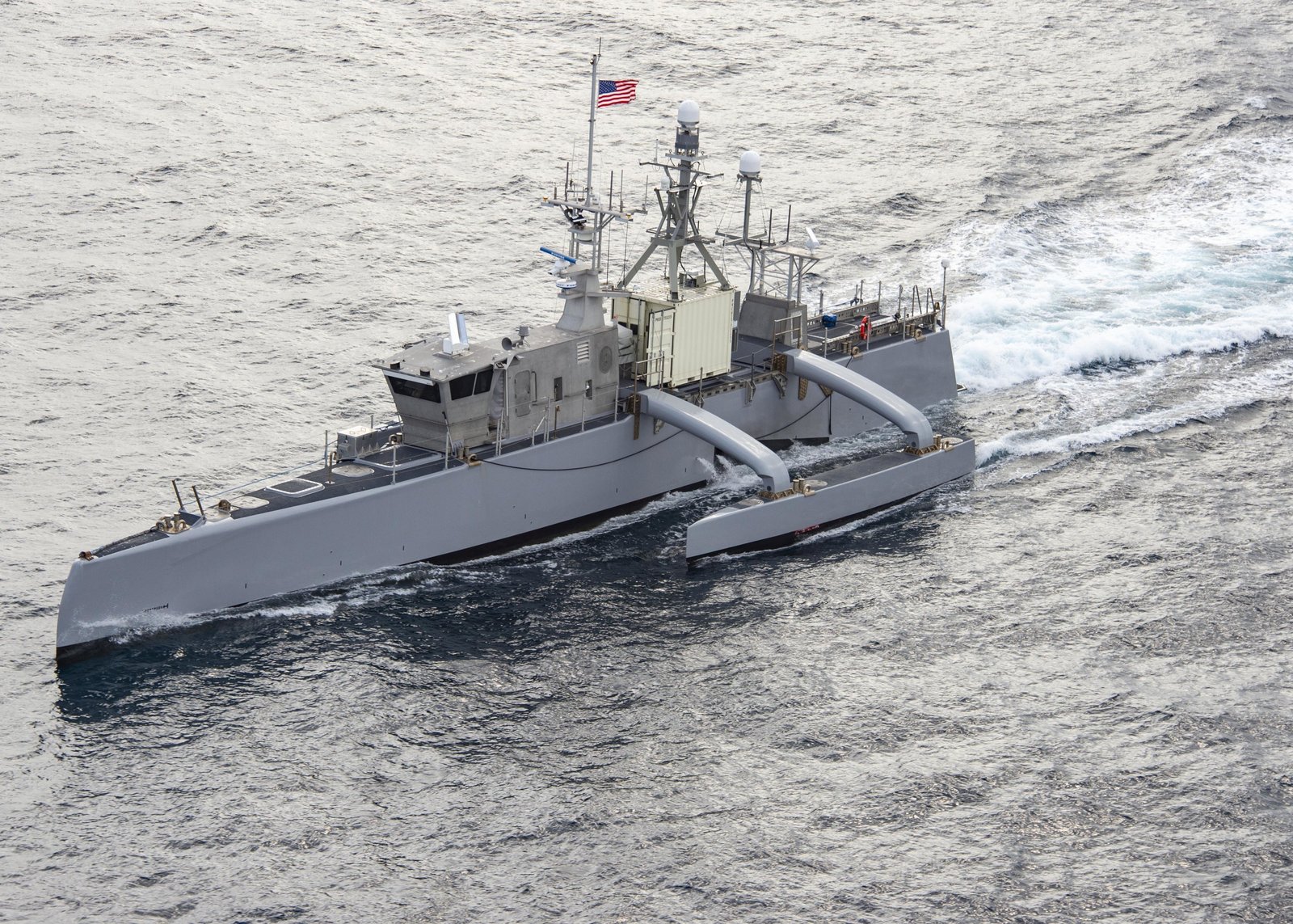 一艘灰色細長型三體船身的無人水面艦 Sea Hunter 在太平洋航行，海面平靜