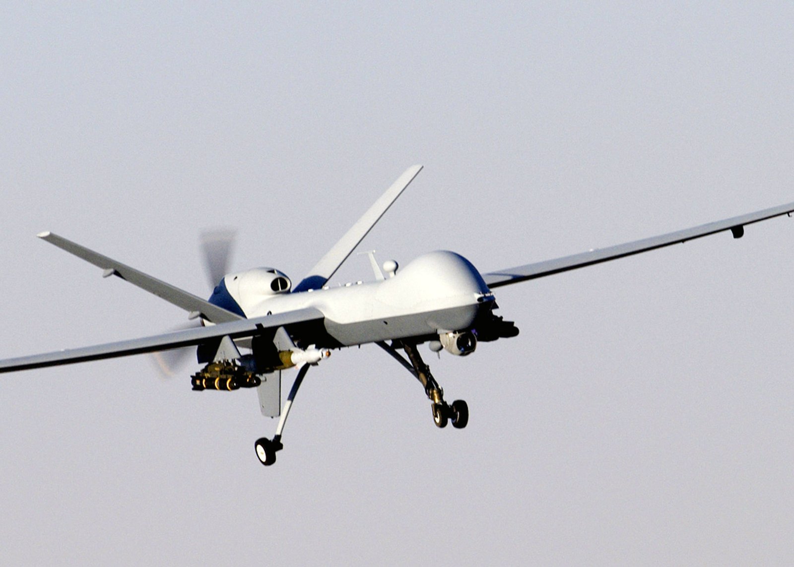 一架 MQ-9 Reaper 無人機掛載武器飛行於山區上空